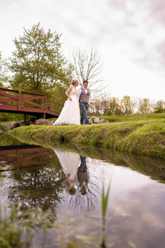 The creek at Ash and Oak Weddings beautifully reflects a couple holding hands at sunset.