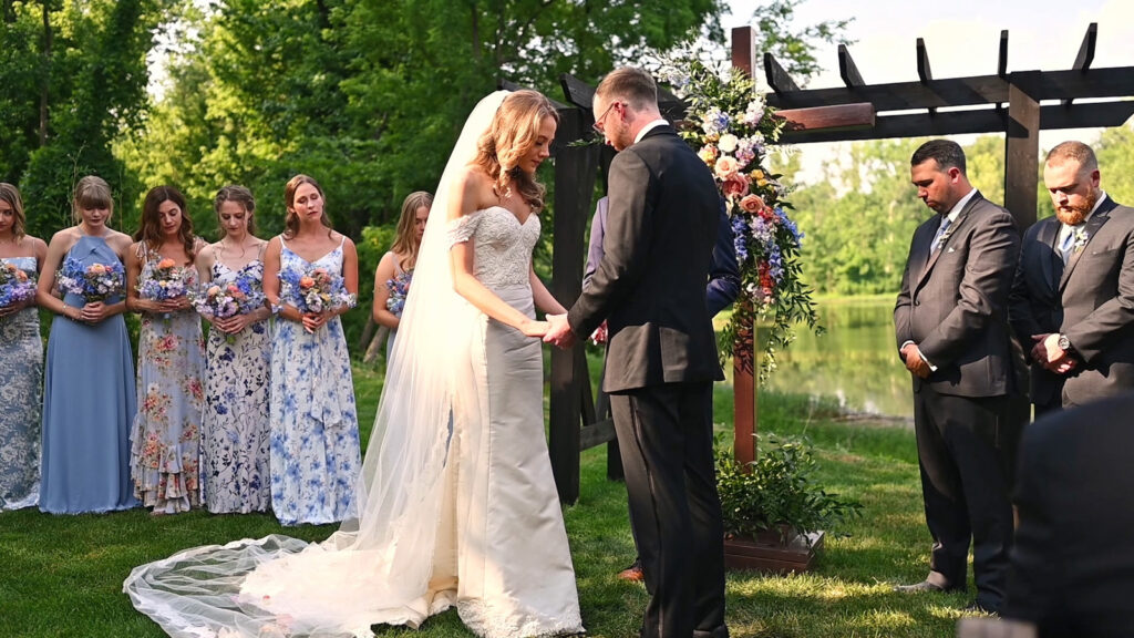 Couple prays during outdoor ceremony at The Conservatory at Evergreen.