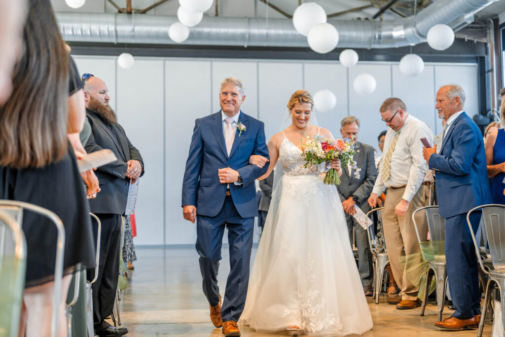 Bride walks down the aisle with her father.