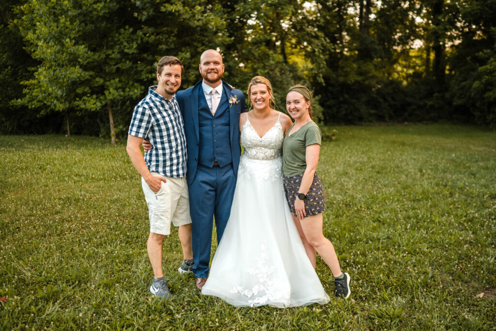 Bride and groom smile with male and female photographers at One World at Woolery Mill in Bloomington, Indiana.