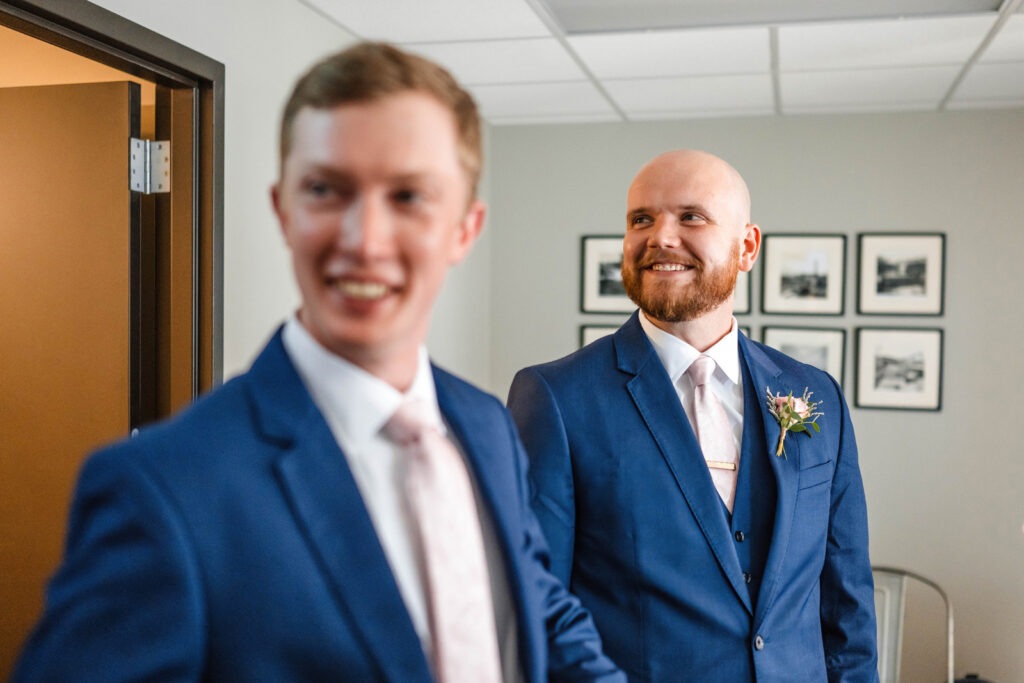 Groom smiling while getting ready with groomsmen.