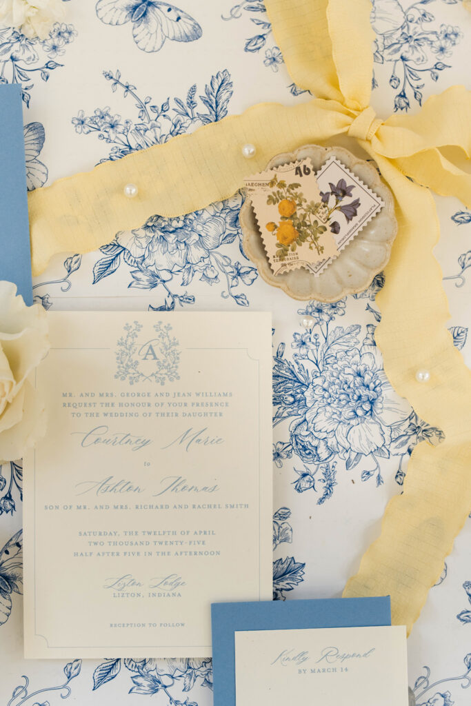 Flatlay of wedding invitation with blue and yellow details.