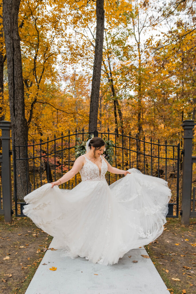 Bride twirls in her wedding gown outside.
