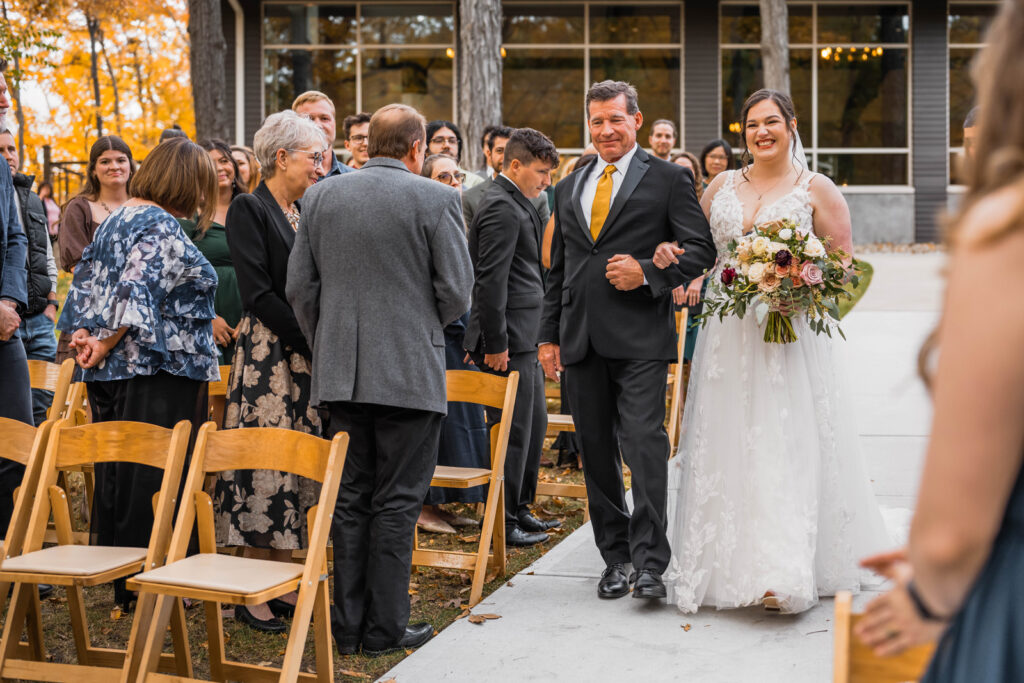 Bride walks down the aisle with her father at The Bluffs at Conner Prairie wedding venue.
