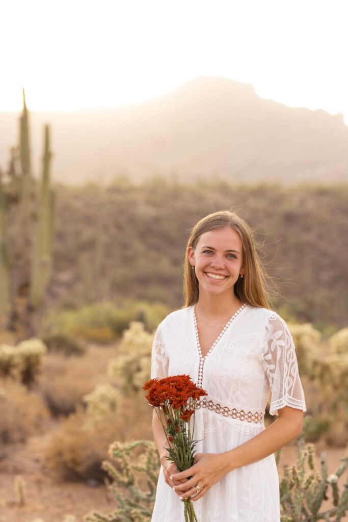 Bride smiles in front of cacti in the desert.