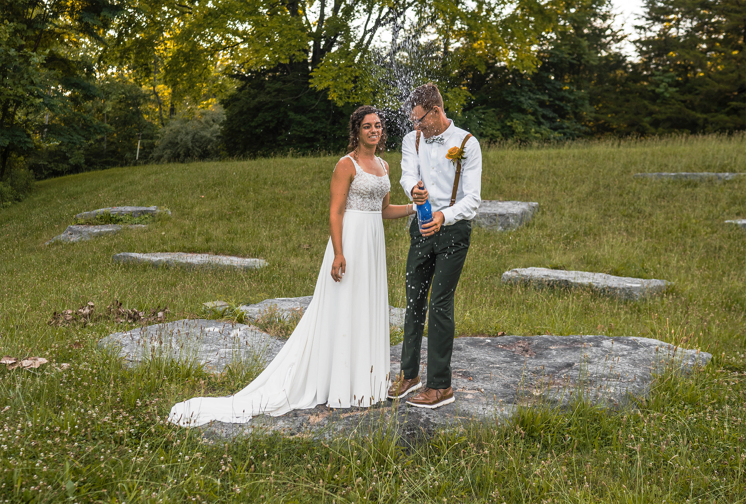 Bride and groom pop sparkling water during their outdoor elopement at DePauw Nature Park in Indiana.