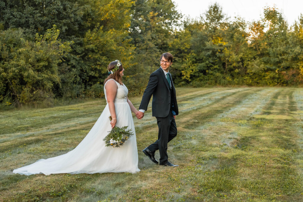 Groom leads bride on a walk after their outdoor wedding ceremony at their Indiana home.
