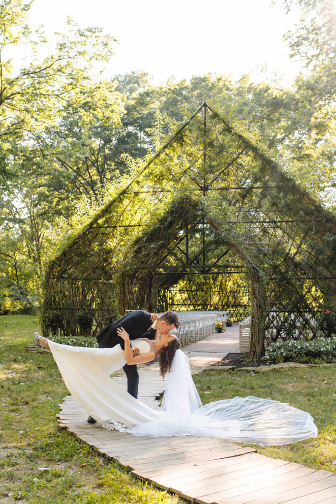 Groom kisses bride in front of Willow Chapel at Black Iris Estate.