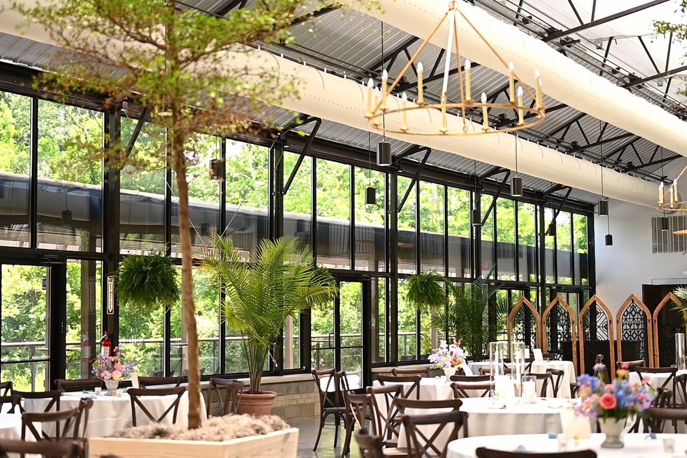 Tall glass windows inside a greenhouse styled wedding venue.