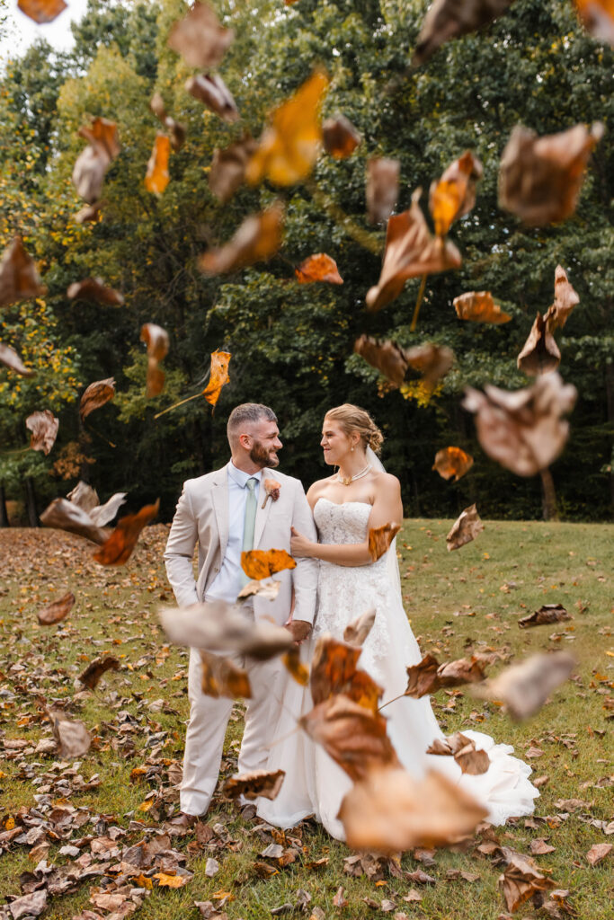 Bride and groom play in the leaves at The Barn at Timber Ridge.